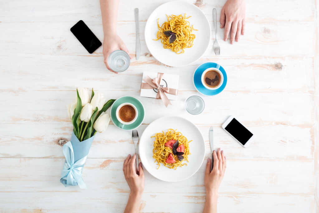 Is Dinner the Perfect online dating Date? hands,of,young,couple,eating,pasta,and,drinking,water,on