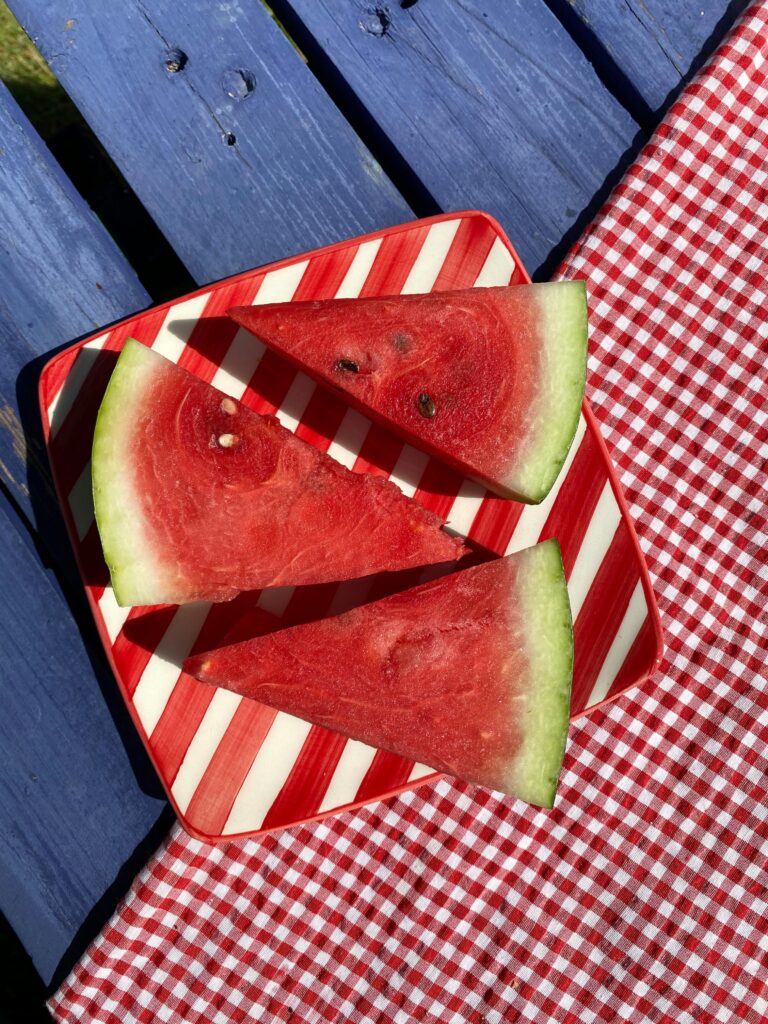 PRESENTATION MATTERS?? Aerial view of juicy watermelon slices on a striped plate with a picnic vibe.